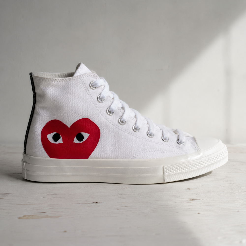 CDG x Converse Chuck Taylor High Top white sneaker with large red heart logo on ankle patch